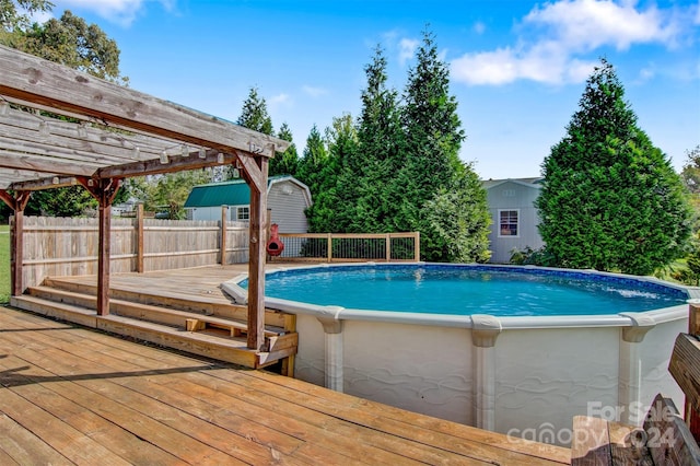 view of swimming pool featuring a wooden deck and a pergola