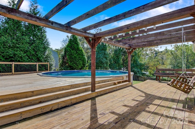 view of swimming pool featuring a pergola and a deck