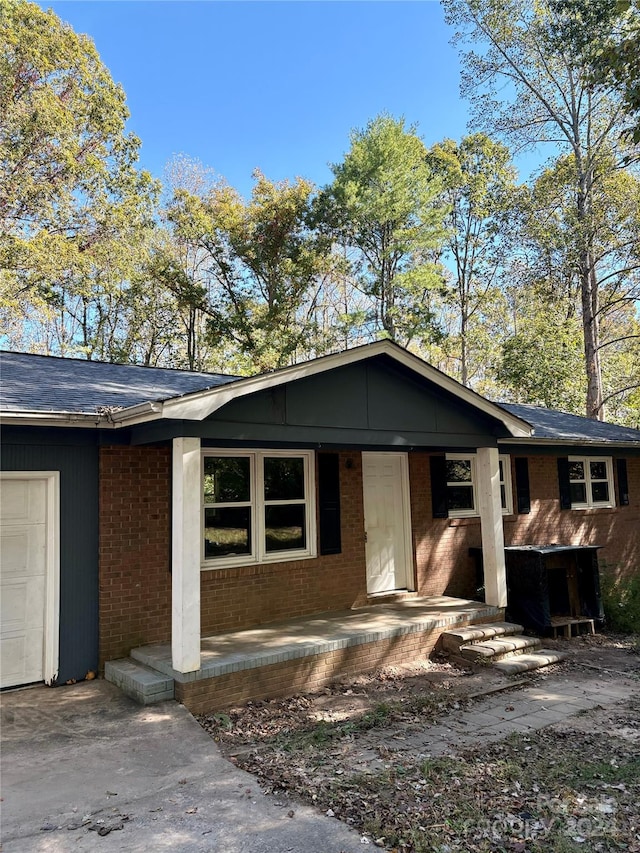 ranch-style home with covered porch and a garage