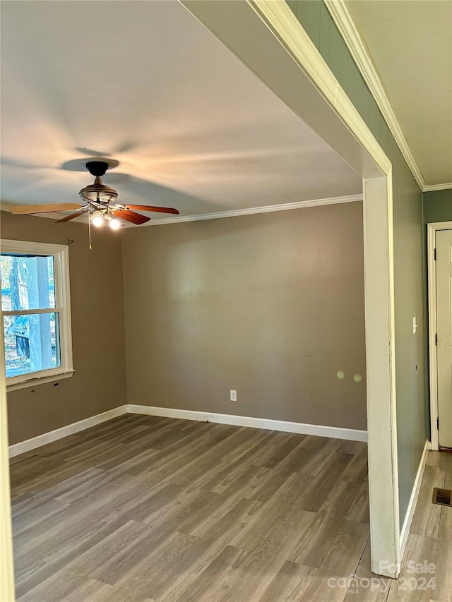 spare room with crown molding, wood-type flooring, and ceiling fan