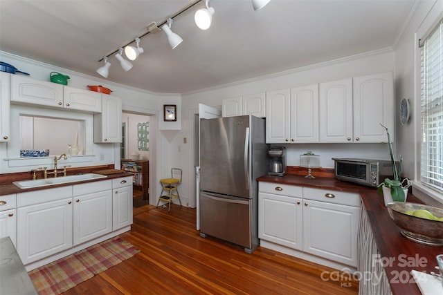 kitchen with dark hardwood / wood-style flooring, white cabinetry, stainless steel fridge, and crown molding