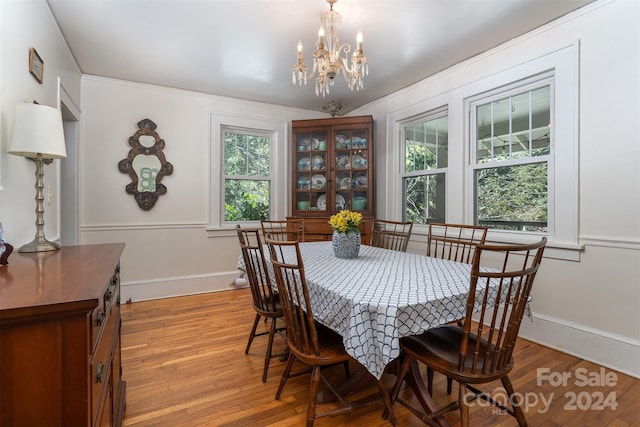 dining area featuring light hardwood / wood-style floors, a notable chandelier, and a healthy amount of sunlight