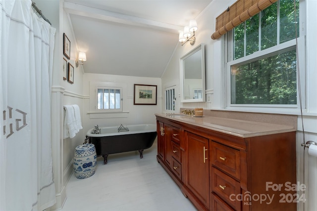 bathroom featuring vanity, a bath, and vaulted ceiling