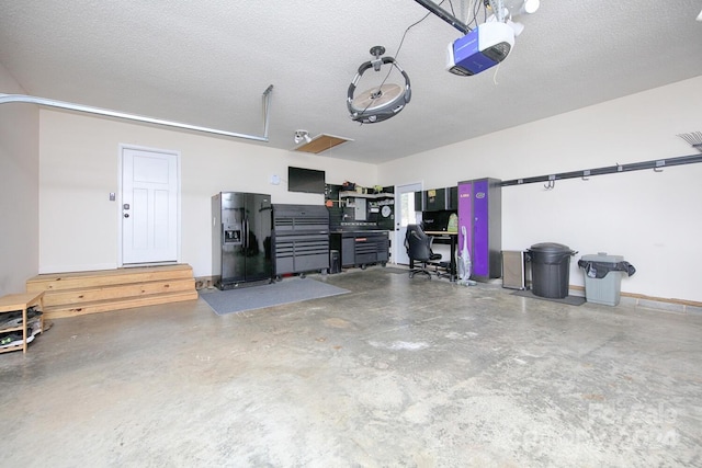 garage with black fridge and a garage door opener