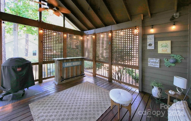 sunroom with ceiling fan and vaulted ceiling