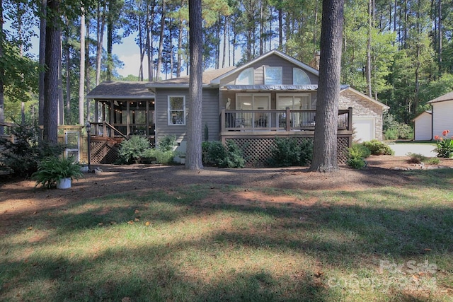 view of front of house featuring a garage, a front lawn, and a wooden deck