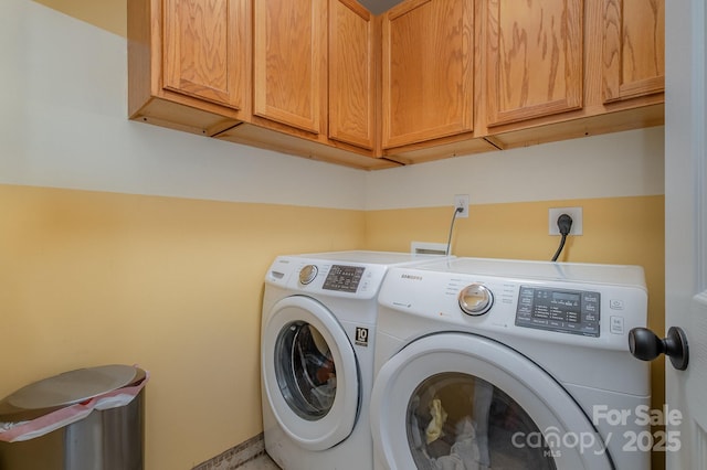 washroom with washing machine and dryer and cabinets