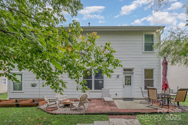 rear view of property with a patio area and an outdoor fire pit