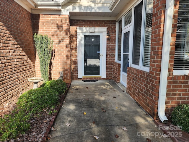 view of exterior entry featuring brick siding