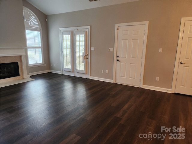 unfurnished living room featuring a high end fireplace, visible vents, baseboards, and dark wood-style flooring