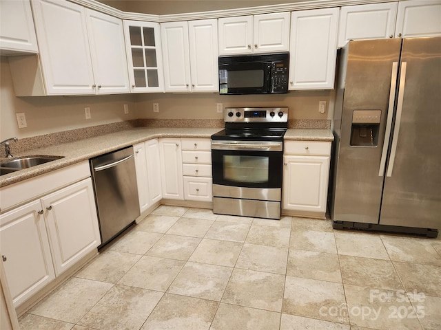 kitchen with a sink, stainless steel appliances, light tile patterned flooring, and light countertops