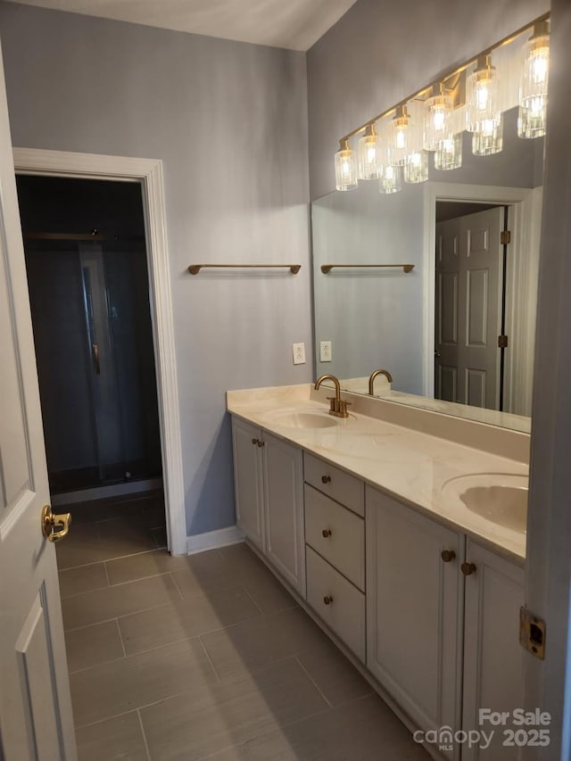 bathroom with double vanity, baseboards, and a sink