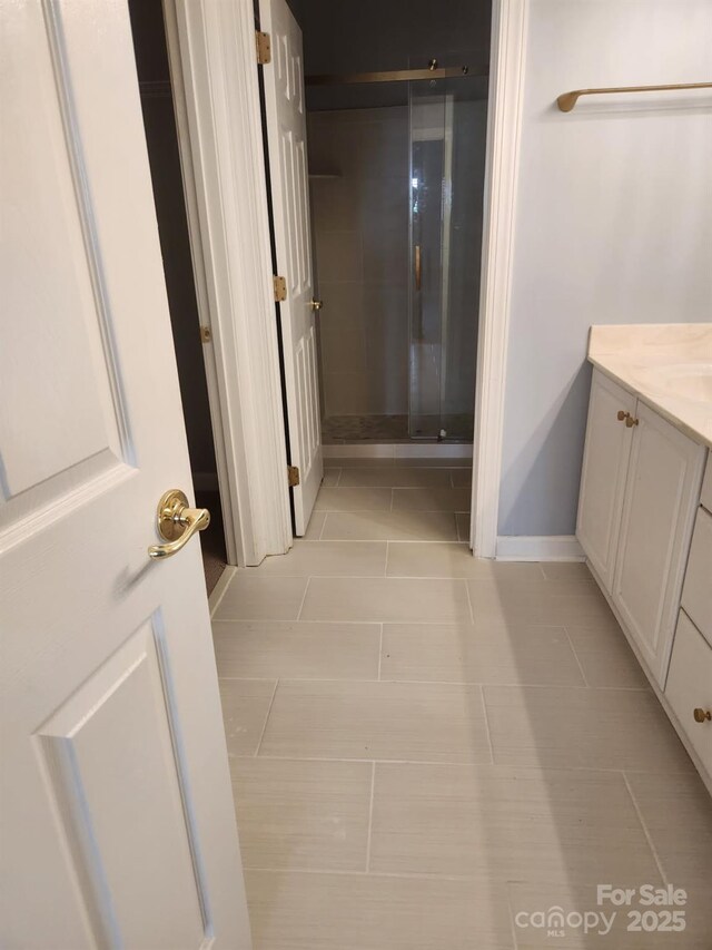 full bath featuring vanity, a shower stall, and tile patterned flooring