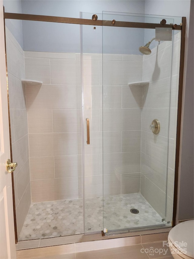 full bathroom featuring toilet and a stall shower