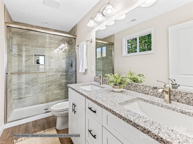 bathroom with vanity, toilet, a shower with door, and hardwood / wood-style floors