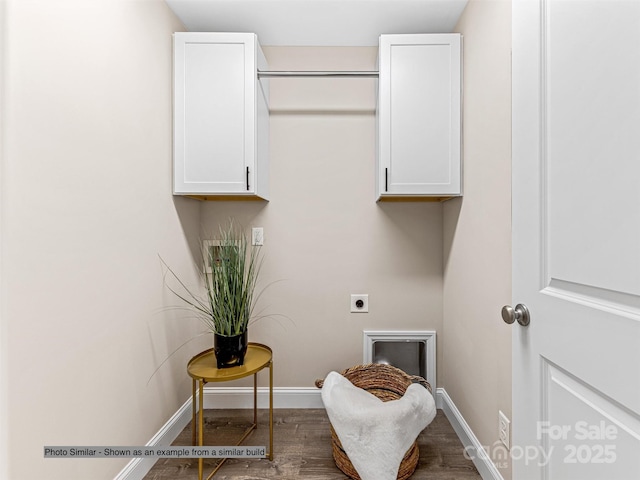 laundry room with electric dryer hookup, dark hardwood / wood-style flooring, and cabinets