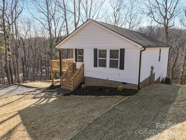 view of front of property featuring cooling unit, a front lawn, and a deck