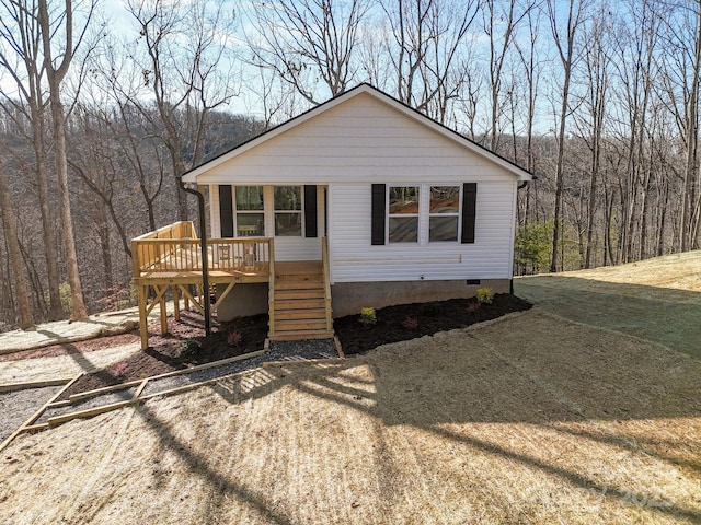 view of front of property with a wooden deck and a front yard