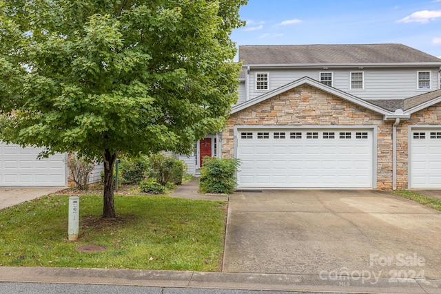 view of front of house featuring a garage and a front lawn