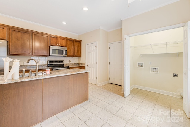 kitchen featuring appliances with stainless steel finishes, backsplash, crown molding, and light stone counters