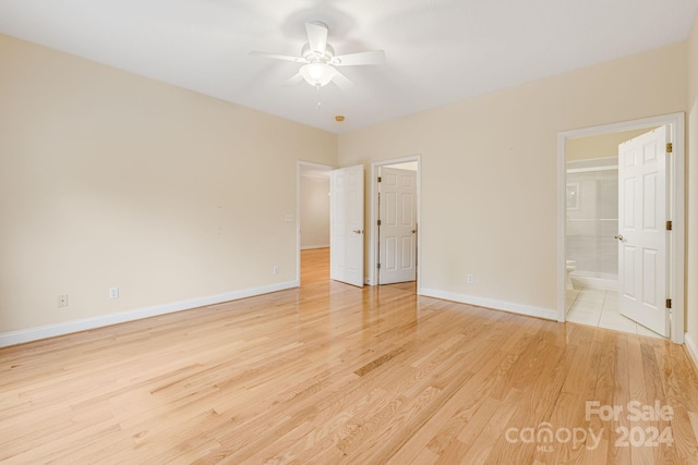 unfurnished bedroom featuring light hardwood / wood-style flooring, ceiling fan, and ensuite bathroom