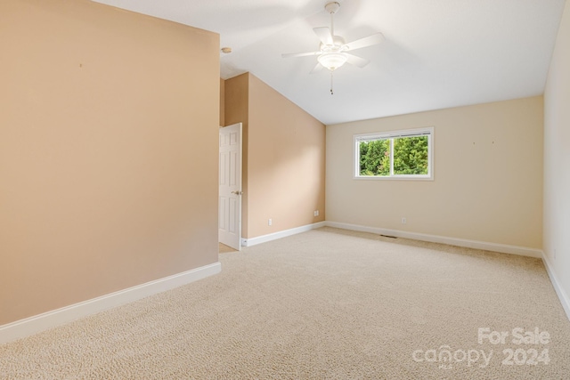 carpeted spare room featuring ceiling fan and lofted ceiling