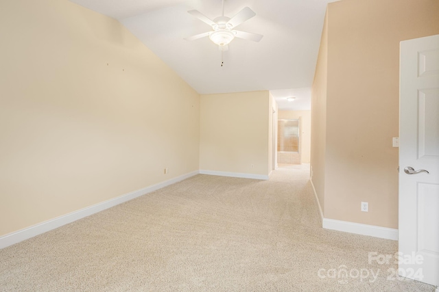 empty room with ceiling fan, light carpet, and vaulted ceiling