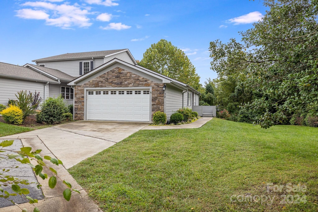 view of front of home featuring a front yard and a garage