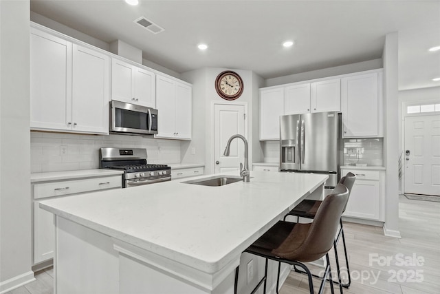 kitchen with a kitchen island with sink, sink, and stainless steel appliances