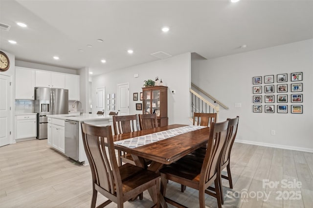 dining room featuring sink and light hardwood / wood-style floors