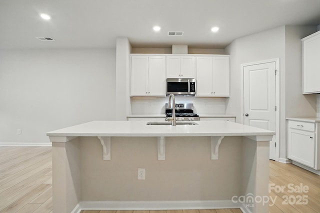 939 Cobbled Way, Fort Mill, SC 29715 - kitchen featuring appliances with stainless steel finishes, a breakfast bar area, light countertops, a center island with sink, and recessed lighting