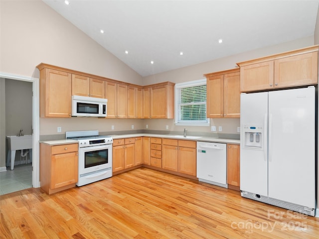 kitchen with sink, white appliances, light hardwood / wood-style flooring, high vaulted ceiling, and light brown cabinetry