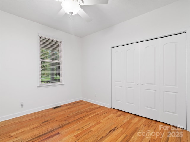 unfurnished bedroom featuring hardwood / wood-style flooring, ceiling fan, and a closet