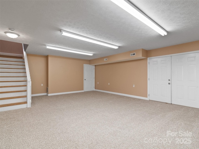 basement featuring carpet flooring and a textured ceiling