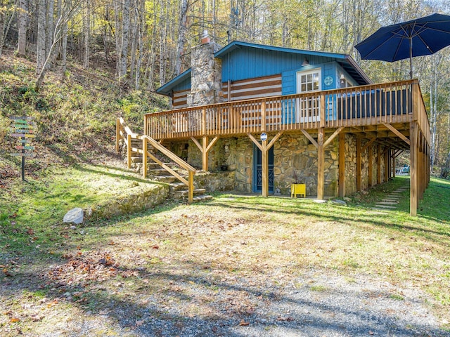 rear view of house featuring a yard and a deck