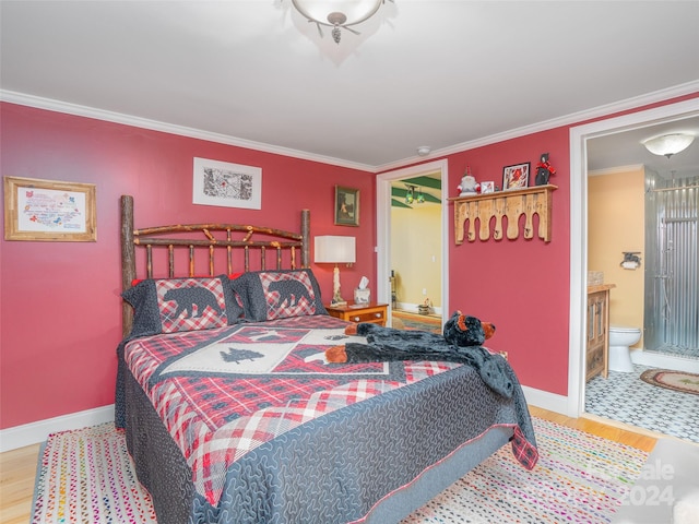 bedroom with ornamental molding, hardwood / wood-style floors, and ensuite bath