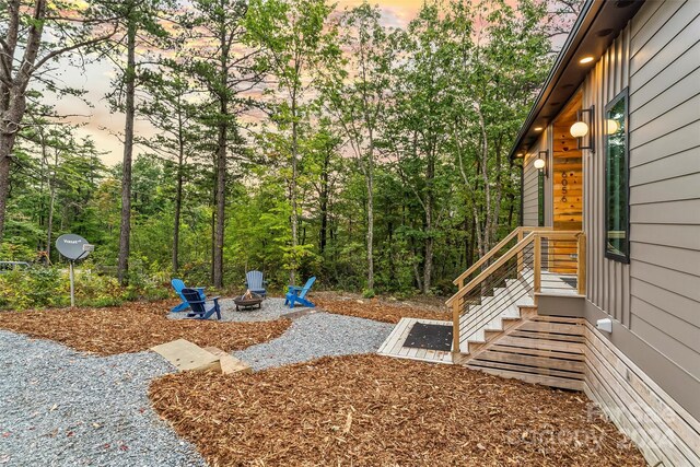 yard at dusk featuring an outdoor fire pit