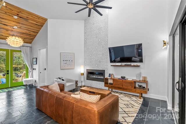 living room featuring wood ceiling, a fireplace, ceiling fan, and high vaulted ceiling