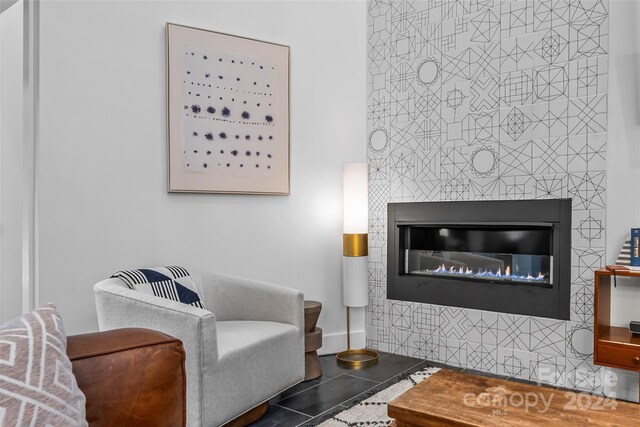 living room featuring a tiled fireplace and tile patterned floors