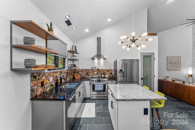 kitchen featuring sink, white cabinetry, wall chimney exhaust hood, stainless steel appliances, and high vaulted ceiling