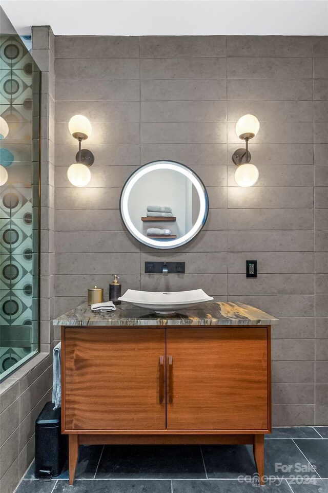 bathroom with tile walls, tile patterned flooring, and vanity