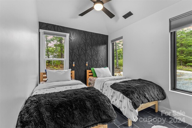 bedroom with ceiling fan and multiple windows