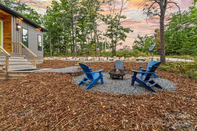 yard at dusk featuring an outdoor fire pit