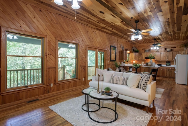 living room with wood-type flooring, wood walls, ceiling fan, and wooden ceiling