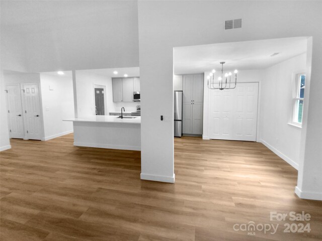 interior space featuring sink, light hardwood / wood-style flooring, and a chandelier