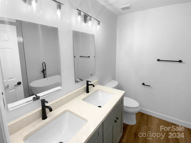 bathroom featuring wood-type flooring, vanity, and toilet