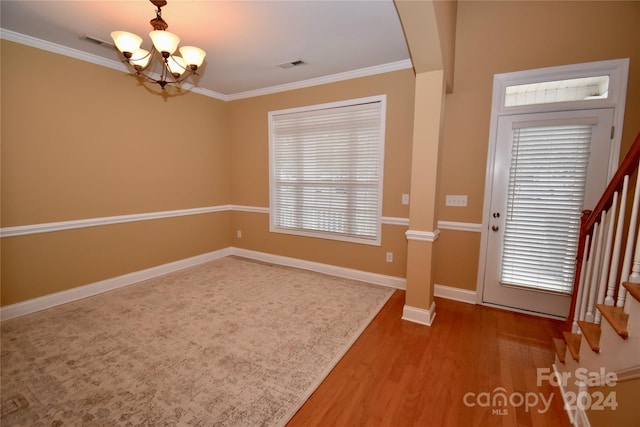 interior space featuring wood-type flooring, a chandelier, and crown molding