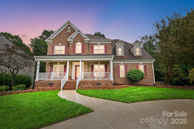 view of front of house featuring a lawn and a porch