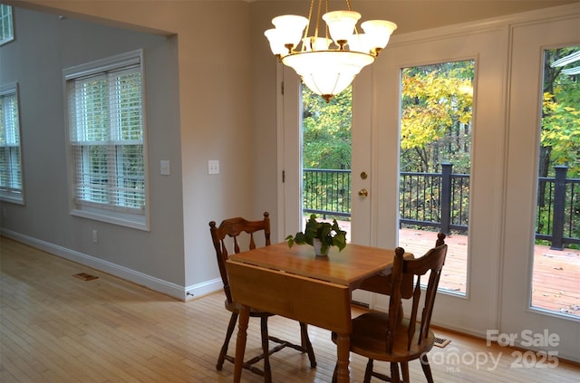 dining room with a chandelier and light wood-type flooring