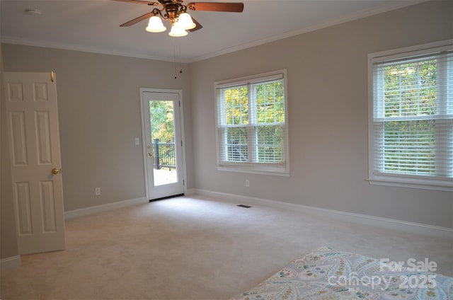 carpeted spare room with ceiling fan and crown molding